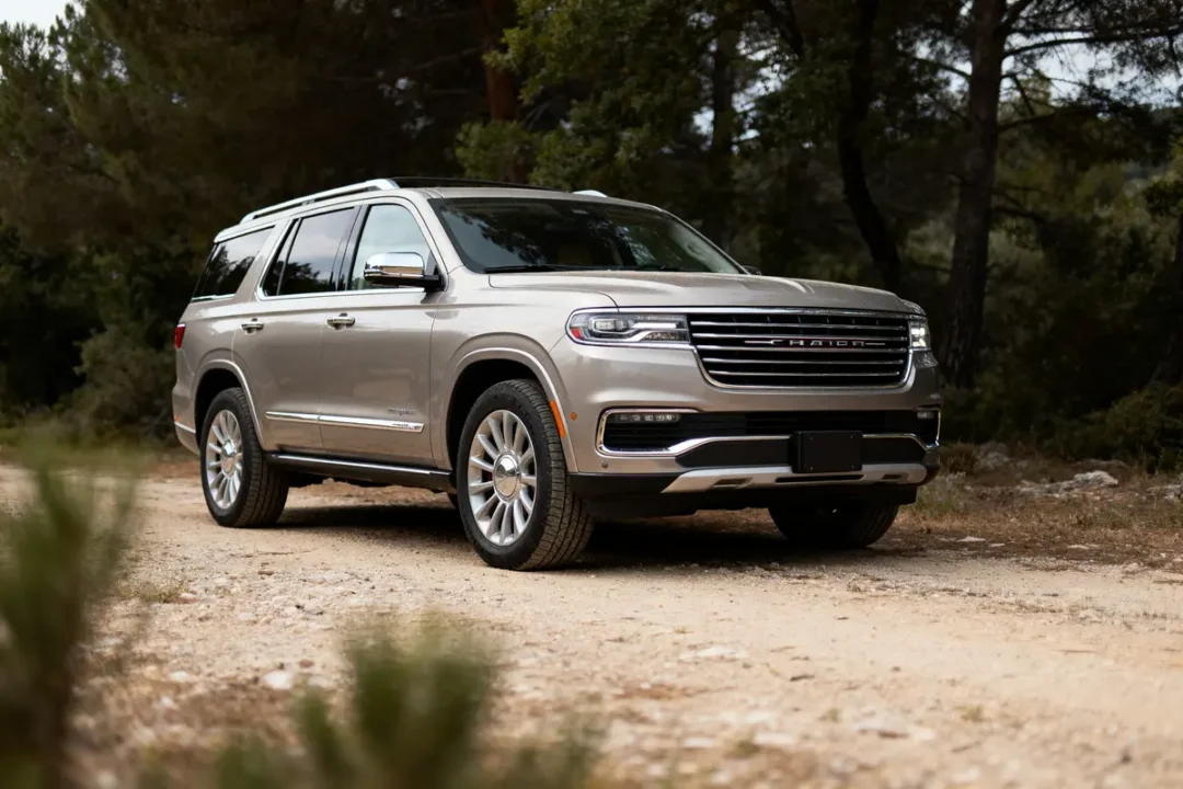 SUV argent garé sur un chemin de terre, entouré d'arbres, journée ensoleillée. Véhicule moderne et robuste.