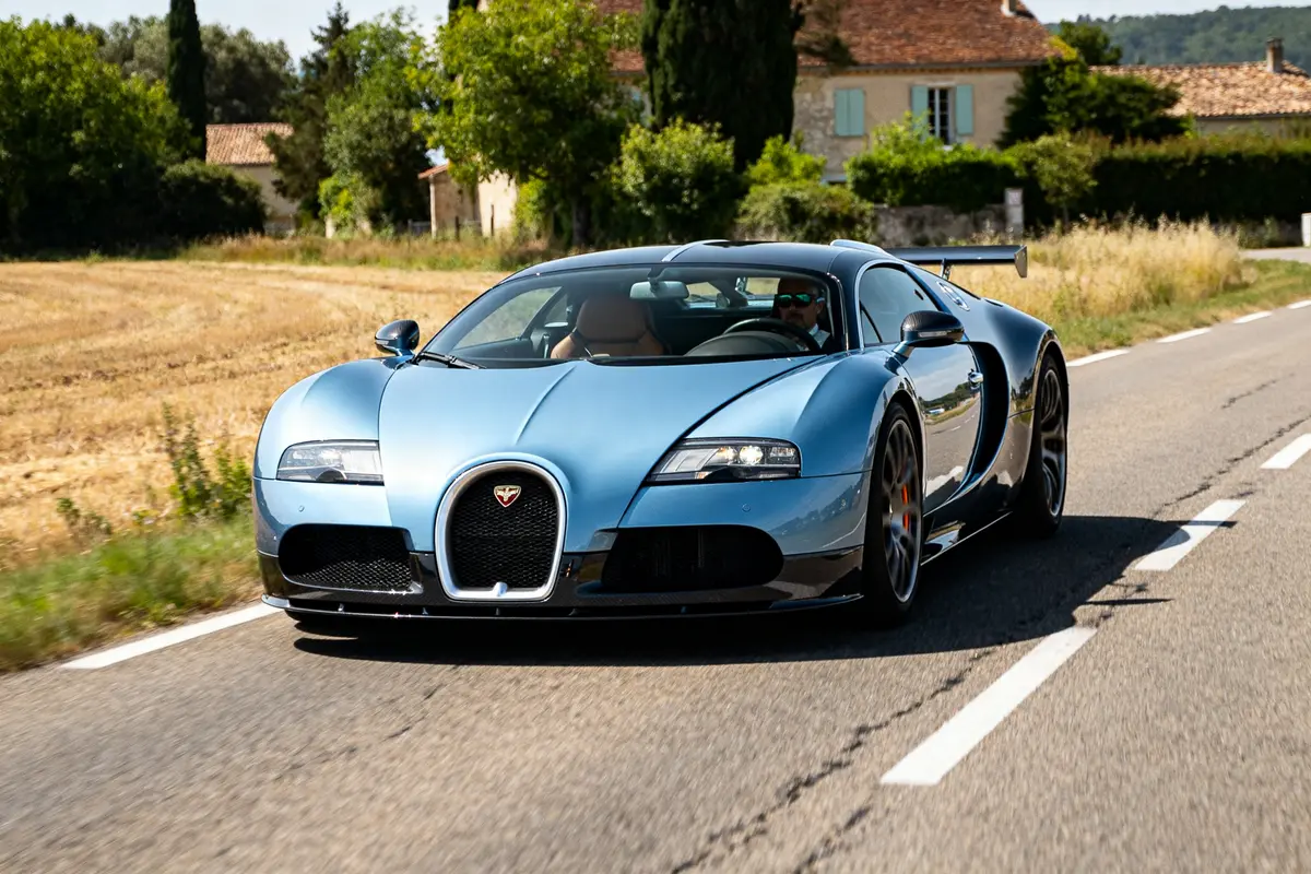 Voiture EB 16.4 Veyron bleue roulant sur une route de campagne ensoleillée