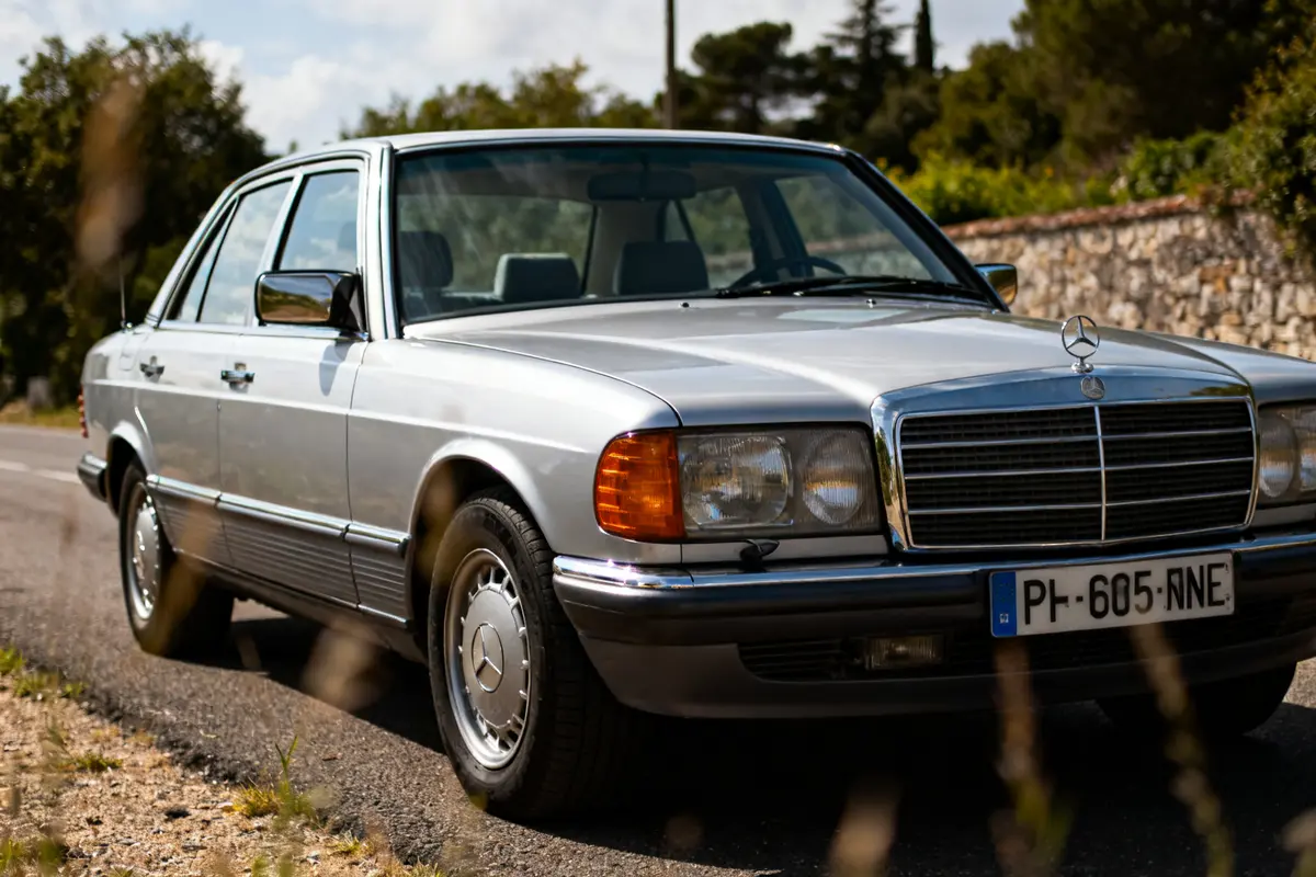 Voiture argentée S124 Mercedes Benz classique sur route ensoleillée vue de face