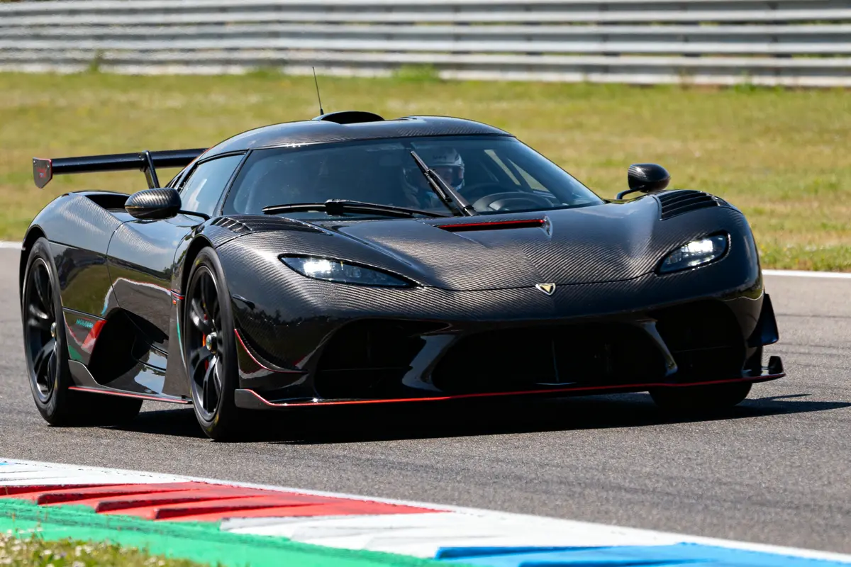 Voiture Valk noire en carbone sur circuit avec fond de barrière métallique