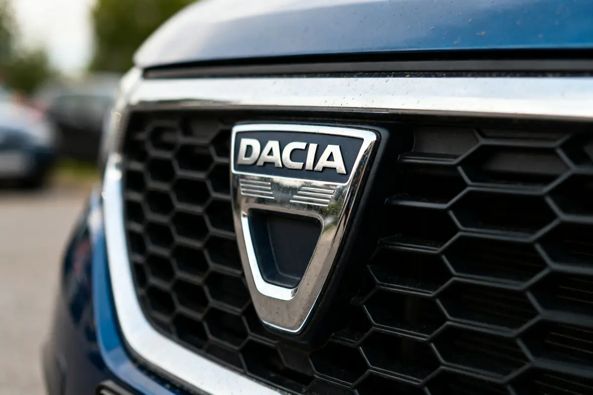 Gros plan sur une calandre de voiture avec le logo Dacia en métal chromé