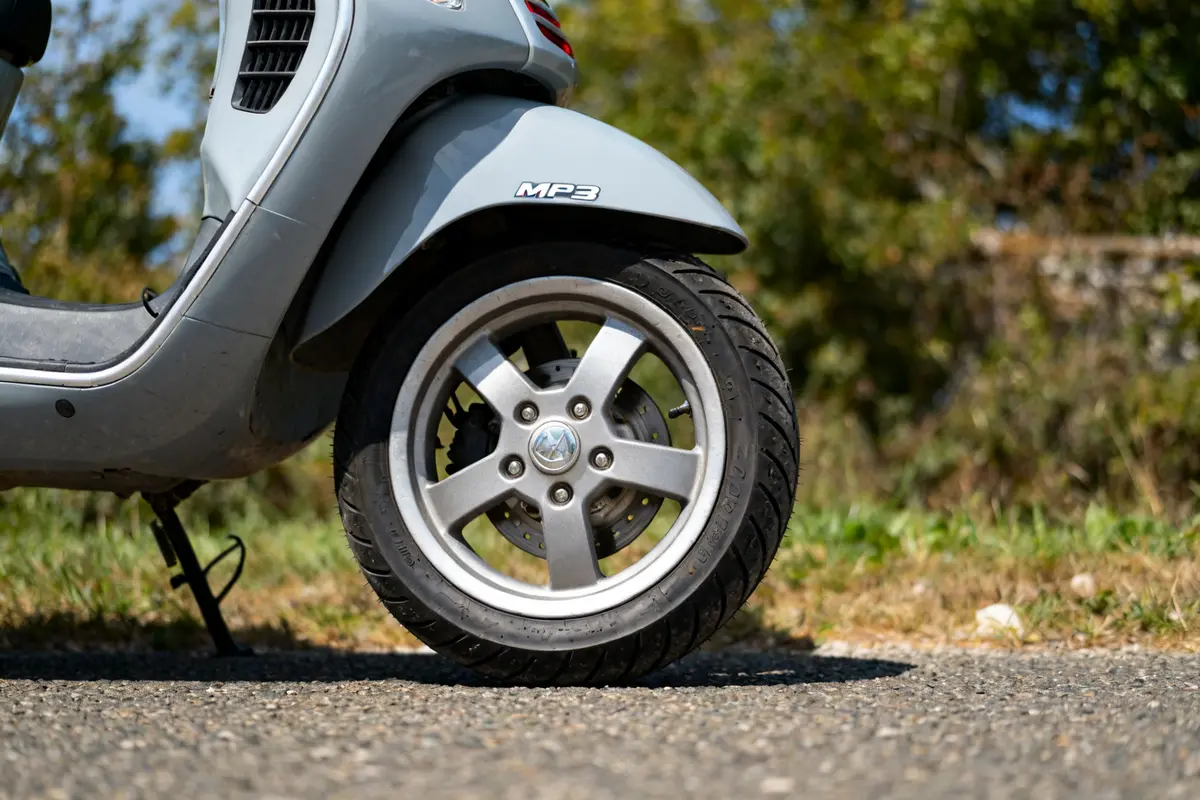 Vue latérale d'une roue avant de scooter gris MP3 500 montrant pression pneus optimale
