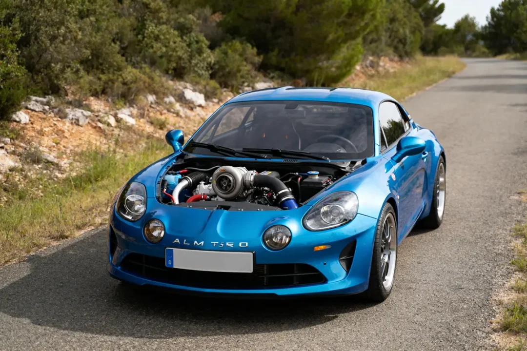 Voiture bleue sportive sur route avec moteur turbo R5 Alpine Turbo visible.