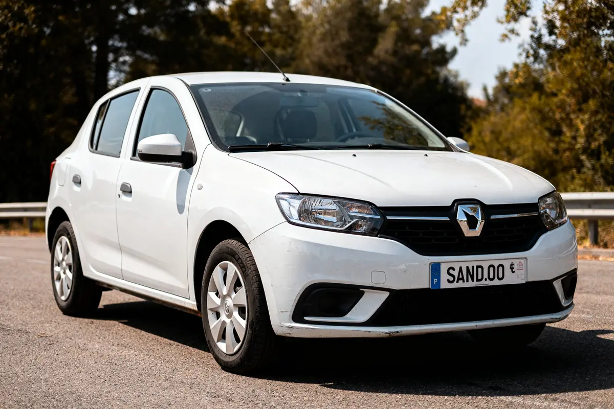 Voiture blanche Dacia Sandero neuve 8000 euros stationnée sur route bordée d'arbres