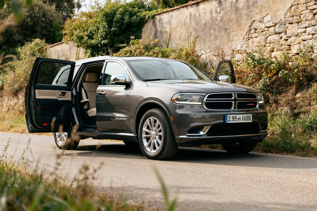 SUV Dodge Durango gris, portes ouvertes, garé sur une route campagnarde.
