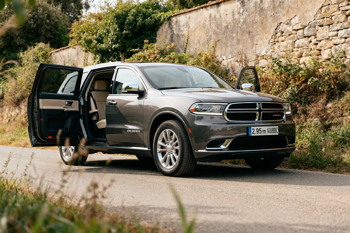 SUV Dodge Durango gris, portes ouvertes, garé sur une route campagnarde.