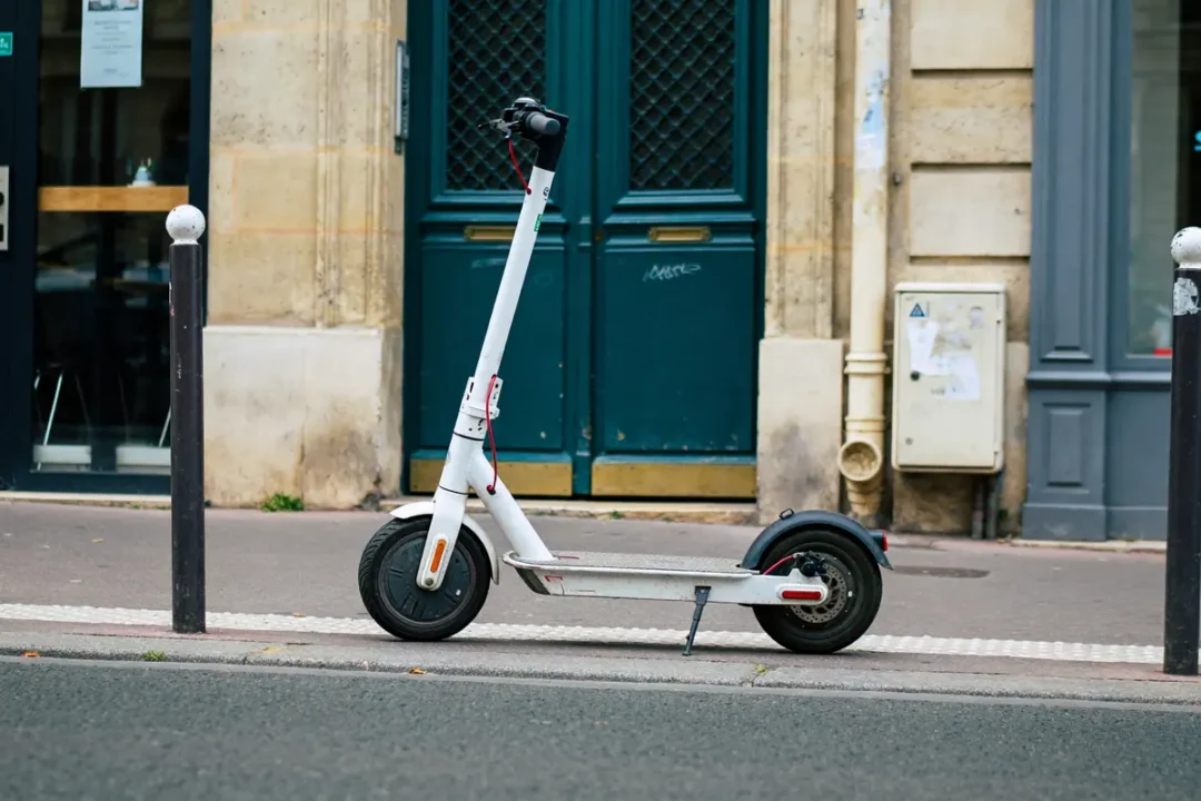 Trottinette électrique garée sur trottoir urbain devant porte bleue illustrant edpm signification