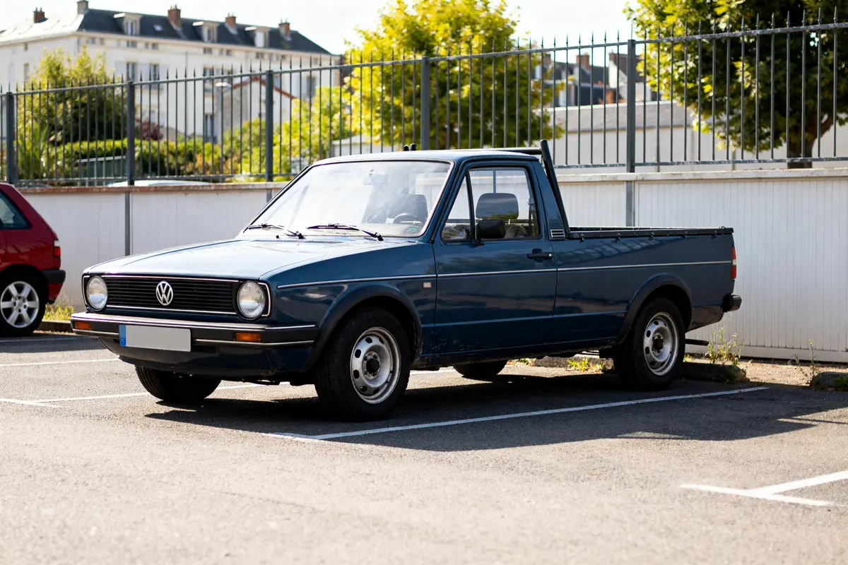 Pickup Volkswagen Golf 1 bleu stationné sur un parking ensoleillé