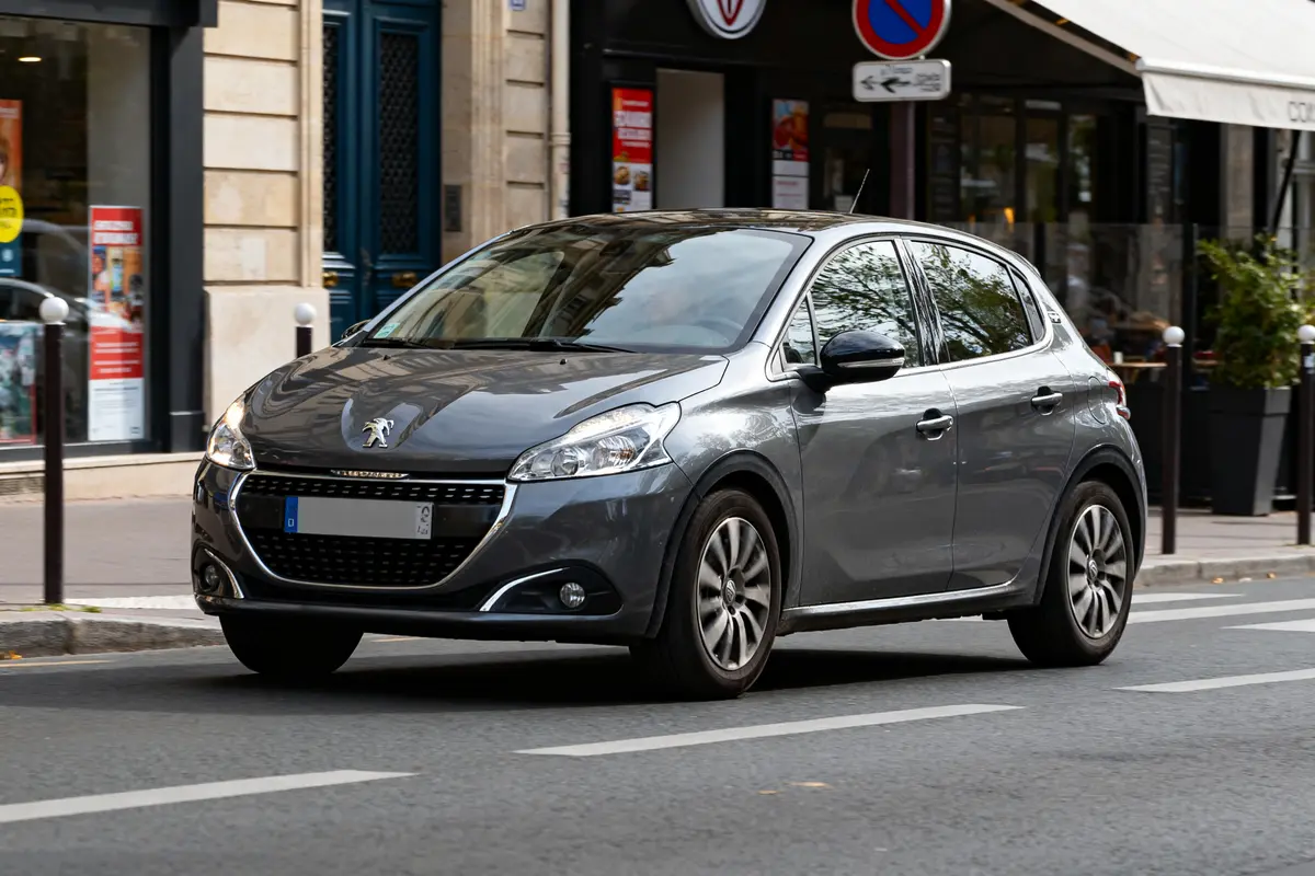 Petite voiture grise française sur route urbaine concurrente de marque de voiture en T