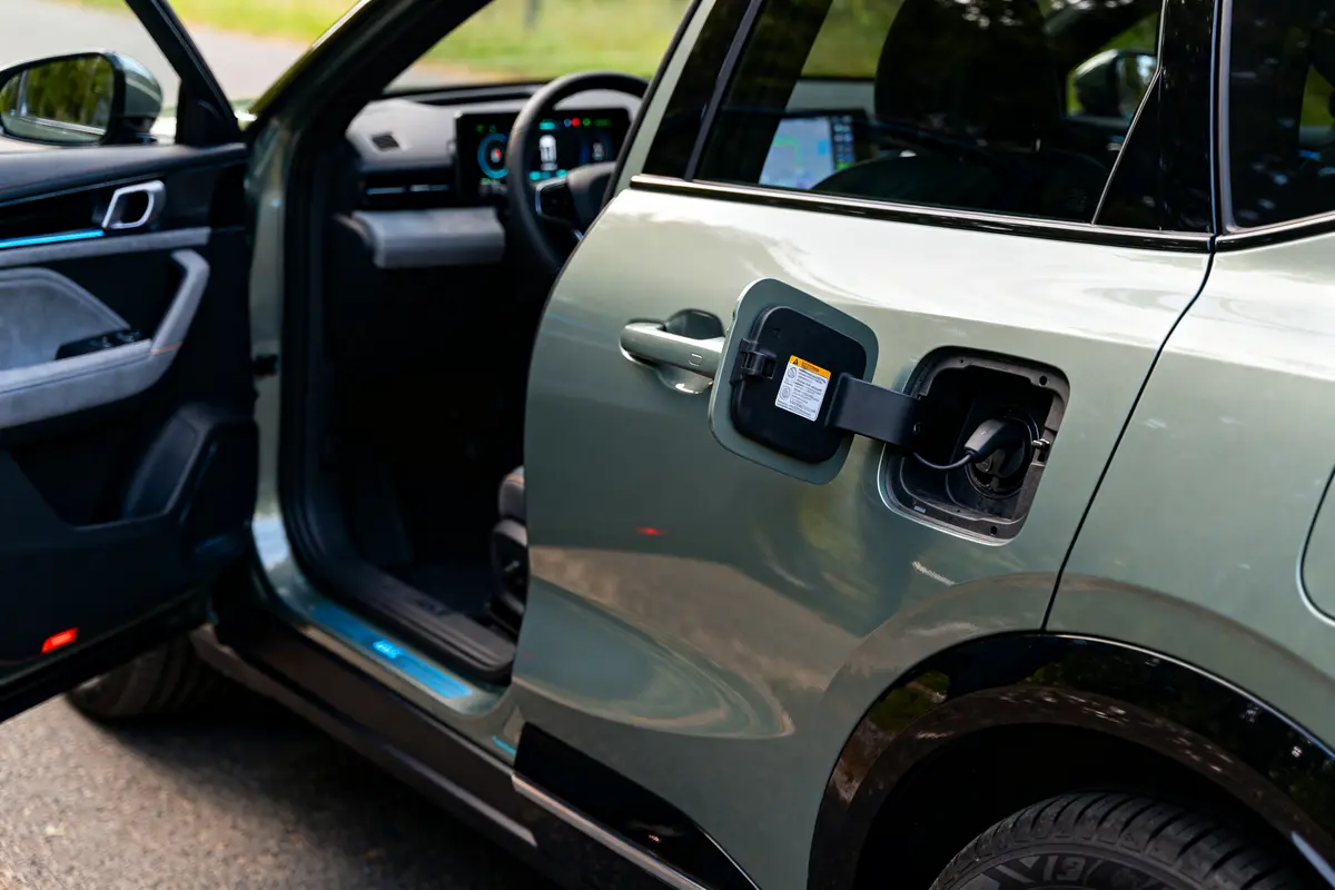 Voiture électrique avec porte ouvert et trappe de recharge visible sur le côté